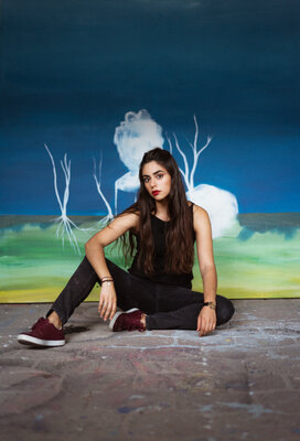 Alexia López Sosa in the Studio: Photo of the artist with her painting "Wonderland". Photo by: Jamesandmoose