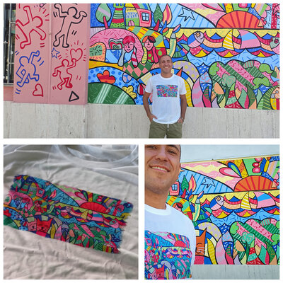 Rosario Annunziata in the Studio: Il murales è stato realizzato in collaborazione con istituzioni pubbliche per promuovere l'inclusione . Si vede il dettaglio della stampa sulla t-shirt