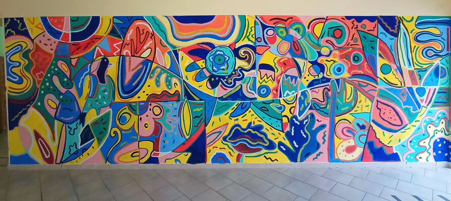 Rosario Annunziata in the Studio: Il murales è stato realizzato in collaborazione con istituzioni pubbliche per promuovere l'inclusione . Si vede il dettaglio della stampa sulla t-shirt