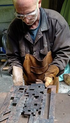 Jérôme Poumès im Studio: Ajustement de plaques d'acier découpées au plasma pour une sculpture murale urbaine.